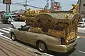 車体が金色に塗られた宮型霊柩車