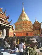 仏塔を前にし、線香、御花、蝋燭などを捧げる仏教徒たち(タイ王国、ワット・プラタートドーイステープ)