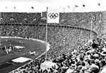 1936年ベルリンオリンピック。客席にヒトラー総統旗（ヒトラーの個人的紋章旗 ）が掲げられている。独裁者ヒトラーはオリンピックをユダヤとフリーメイソンが発案したと考えていた。ヒトラーは最初のうち開催を嫌がったが、側近から政権を高らかに謳うことができると説得され開催する気になった。プロイセン州首相ヘルマン・ゲーリングが、国家社会主義ドイツ中にフリーメイソンの居場所などどこにもないと声明を発表したのは1933年である。