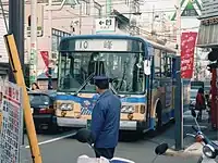 10系統と93系統には車掌が乗務し(左)、杉田駅前では車外に出てバスを誘導していた(右)(1994年12月10日撮影)