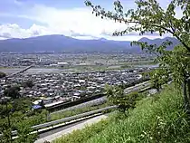 画像左 : 松田町内の東名。奥は酒匂川で、高速道路の建設に適した酒匂川と手前の山地間の平野は、人家、道路などで全て埋め尽くされていた。このため東名は画面手前側の山沿いに計画された。画像右 : 鮎沢付近の東名最大規模の長大切土。切り取り高さ75 m、掘削土量約5万立方メートルに及んだ。こうした長大切土は自然のバランスを崩すことから負の条件を持つ。工事中の災害の危険が伴い、開通後も崖崩れの恐れがある。そうした危険を回避する意味でも山北の場合は都夫良野トンネルが掘削された。