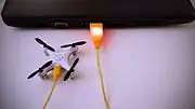 マイクロUSBケーブルで充電中の超小型クワッドコプター