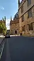 Catte Street looking South towards the Radcliffe Camera from outside Hertford College and the Bodleian Library which is the forground. There is a car on the street.