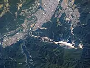 秩父市付近の人工衛星写真(2014年9月27日撮影)。写真上方が北側。市街地の南に武甲山に連なる石灰岩採掘場が見える。提供:プラネット・ラボ社