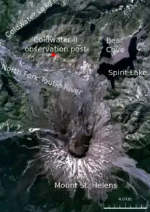 地名が様々な位置に付与されたセント・ヘレンズ山周辺の衛星画像。記載された主な場所は以下のとおり：セント・ヘレンズ山（円形の黒い火口を有する火山の中央）、火山の北側に「コールドウォーターII観測所」（ジョンストンが宿直していた場所）、他の場所は3つの湖（スピリット湖、ベア・コーブ、コールドウォーター湖）と河川（ノース・フォーク・トゥートル川）。
