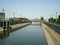 第二寝屋川川俣大橋より下流を望む。見える橋は川中大橋。左岸に見えるのは川俣ポンプ場との合流口。