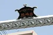 蝙蝠型の銘版。日本語表記は「出嶋橋」英語表記は「DESHIMA-BASHI」となっている。