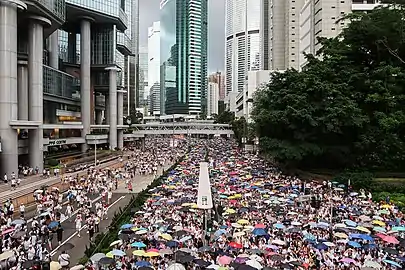 金鐘道（中国語版）では夕方に一時雨が降り、デモ参加者が2014年香港反政府デモのときのように傘をさした