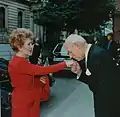 身分の高い人物に対して（へりくだって）行う、手への接吻（hand-kissing）。かつて王に対して臣下が、貴婦人に対して騎士が、教皇に対して人々が、さかんにこうした挨拶をした。ヨーロッパの貴族の伝統や宮廷文化をほうふつとさせ、優雅さを感じさせる挨拶である。現代でも、非常に深い尊敬を表現したり、「うやうやしさ」を表現したり、女性に喜んでもらうために、あえてこの挨拶がされることがある。