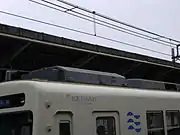 1987年製造車用(左)1988年製造車用(右)の補助電源装置。画像では、乗務員扉上部に水切りがある1988年製造車(左)に、1987年製造車用の張り出しのある補助電源装置が、1987年製造車(右)に1988年製造車用の補助電源装置が搭載されている。