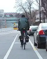 駐車帯の左横(車道中央側)に引かれた自転車レーンを通行する自転車