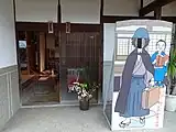 玄関前。横溝と金田一耕助の表札がかかっている。右側は金田一の顔出しパネル。