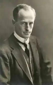  Man, mid-thirties, receding hair, clean shaven, wearing a high collar with tie. He is facing half right but his eyes are on the camera.