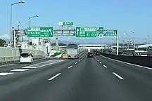 画像左：一般有料道路区間の入口に設置された規制標識群（東海IC下り線）。高速自動車国道と一般有料道路（国道302号）の境界を視覚化すると共に、最高速度を100 km/h（大型貨物、トレーラーは80 km/h）、最低速度を50 km/hとする速度規制を行う。トレーラーの走行位置を左車線に規制する標識も設置されている。画像右：一般有料道路から高速自動車国道へ進入する際は「ここから高速道路」の標識を提示して規制解除を実施（東海IC上り線）。