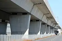 橋脚の天端を高く構築することで沓（支承）を隠し、雨水による汚れを目立たなくさせた。左画像は伊勢湾岸自動車道の高架橋で沓が露出することで橋脚が汚れているが、右画像の藁科川橋では沓を隠して汚れが目立たない。