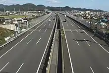 画像左 : 新東名として2012年に開通した静岡県区間の島田金谷IC付近。ICやSA等の分合流箇所では付加車線追加として当初から片側3車線で運用。画像右 : 岡崎SA付近。愛知県区間は用地は往復6車線で取得済みだが構造物は往復4車線仕様。このため静岡県区間と比べると幅員は狭い。