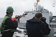 HMCS ウィニペグ(FFH 338)艦上よりフランス海軍補給艦ソンム(A631)（英語版）に向けてアーマライト AR-15改造の索発射銃を構えるカナダ海軍兵(2015年)