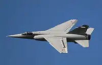 左にロールしている、スペイン空軍のミラージュF1M。右主翼端の補助翼が下がっていることと、左主翼端の補助翼が上がると共に左主翼上面のスポイラー（フラップの前に設置）が作動していることに注目。