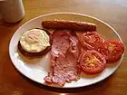 イギリス(やアメリカ)での典型的な朝食の一種。目玉焼き + ベーコン・ソーセージ類 + 焼きトマト。