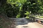 南東側からの登山道。二村台7丁目の住宅地内にあり、唯一自動車の乗り入れができる山道である。鎌倉街道の東側からの登山道であり、登り切った付近が小峠と呼ばれる。（2012年（平成24年）5月）