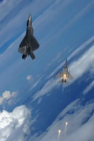 F-22とフレアを放つ第325戦闘飛行隊所属のF-15(2008年9月22日)