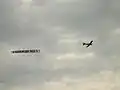 幕を牽引して飛行するFA-200（2011年）