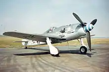 コンクリート上に駐機した第二次世界大戦中の戦闘機の写真