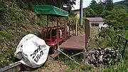 藤倉乗降場で待機する中組線のモノラック車両。奥の建物は旧藤倉小学校