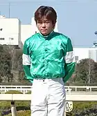 緑色ベースの貸し勝負服を着用中の小牧