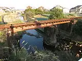 単線上路デッキガーダー橋(単純桁橋)島原鉄道。中央の橋脚の両側に高さの違う2本の桁橋が架かっている。