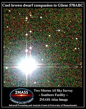 グリーゼ570系の画像。左下にある明るいのがA、そのすぐ右上にBとCの連星系がある。褐色矮星のDは矢印の先にある。(2MASS撮影)