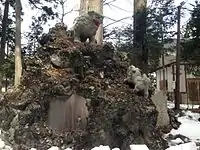 「獅子の子落とし」を模する富士塚の狛犬(阿形)