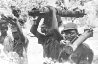 分解したB-10無反動砲を運ぶギニアビサウ軍の兵士（1960年代後半）