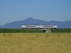 米山をバックにほくほく線を走るHK100形（2014年9月 くびき駅-犀潟駅間）