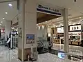 イオンモール1Fにある地下改札口へのエスカレーター（2016年8月）
