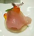 日本料理の影響を受けたアミューズブーシュの例:ハマチ、イクラ、バジル、バジルの花を盛りつけたもの。
