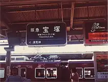 1. 阪急電鉄の駅名標の例(1984年当時の宝塚駅)。1986年までの駅名標は漢字とローマ字の表記しかなかった。