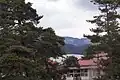 小学校の屋根越しに見た梓川対岸の里山。この里山の向こうに穂高連山があるはず。12年3月22日撮影
