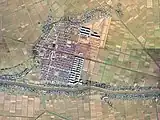 1975年の空中写真。県営アパートや戸建て住宅の団地が形成され、駅は東側に移転。国土交通省 国土地理院 地図・空中写真閲覧サービスの空中写真を基に作成