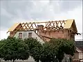 組積造で煉瓦造の家屋の屋根部分の建築段階。壁をレンガで積み上げた上に、その上に載せるように、木製の小屋組みを作る。(チェコの建築現場にて)