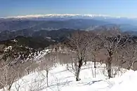 東側の眺望中央付近に古川国府盆地、遠景は飛騨山脈、左から僧ヶ岳、越中駒ヶ岳、毛勝三山、大日岳、奥大日岳、立山、薬師岳、北ノ俣岳、水晶岳、黒部五郎岳、ワリモ岳、鷲羽岳、三俣蓮華岳、双六岳、笠ヶ岳、槍ヶ岳、大喰岳、中岳、南岳、北穂高岳、涸沢岳、奥穂高岳、西穂高岳、前穂高岳、焼岳、霞沢岳、右手前にブナこのさらに右側には乗鞍岳と御嶽山が見える