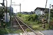 線路奥の遮断機横にある空き地が駅跡（2006年。西別所3号踏切から）