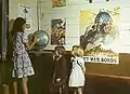 テキサス州サンオーガスティン郡の小学校(1943年4月)。壁に「戦時国債を購入せよ」と書かれたポスターが貼ってある。