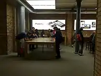 An Apple Store with people trying out the iPhone 4S