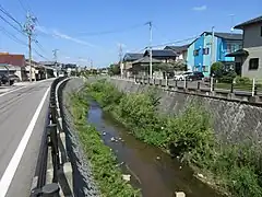 平成20年8月末豪雨の後、伊賀川では堤外家屋の移転と撤去、河川の断面拡大と護岸工事などが行われた（写真右側が元能見町）。