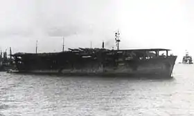トラック島泊地に停泊する冲鷹1943年5月、駆逐艦潮より撮影、特設艦船を挟んで姉妹艦雲鷹も写っている。