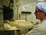 成形したパンを業務用オーブンに入れるところ（イギリス）