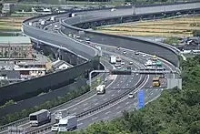 画像左：伊勢湾岸自動車道は基本往復6車線、設計速度100 km/hで運用。画像右：名古屋港の各ふ頭に乗り入れることが伊勢湾岸自動車道の特徴である。画像は金城ふ頭に敷設された名港中央IC。なお港を高規格幹線道路が貫くのは名古屋港のみである。
