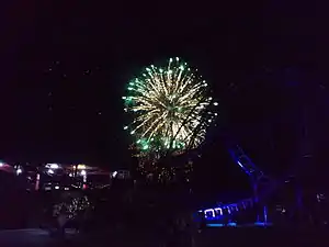 ジェットコースターの奥で上がる花火