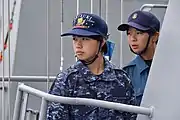 迷彩作業服・部隊帽(左)と艦上戦闘服(右)を着用した女性自衛官(WAVE)